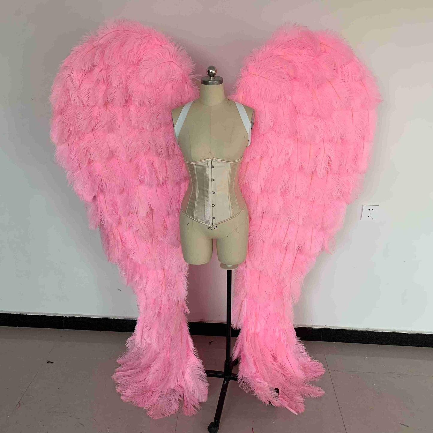 Our luxury bright pink angel wings from the front. Made from ostrich feathers. Wings for angel costume. Suitable for photoshoots especially for boudoirs.