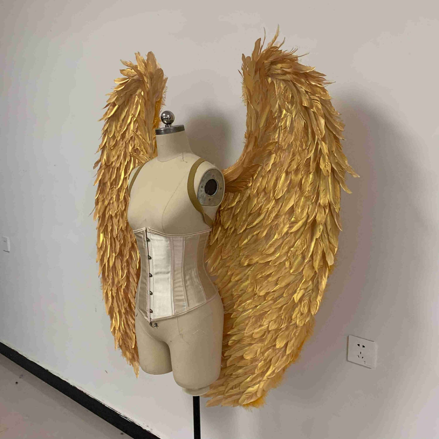 Our golden color angel wings from the left side. Made from goose feathers. Wings for angel costume. Suitable for photoshoots.