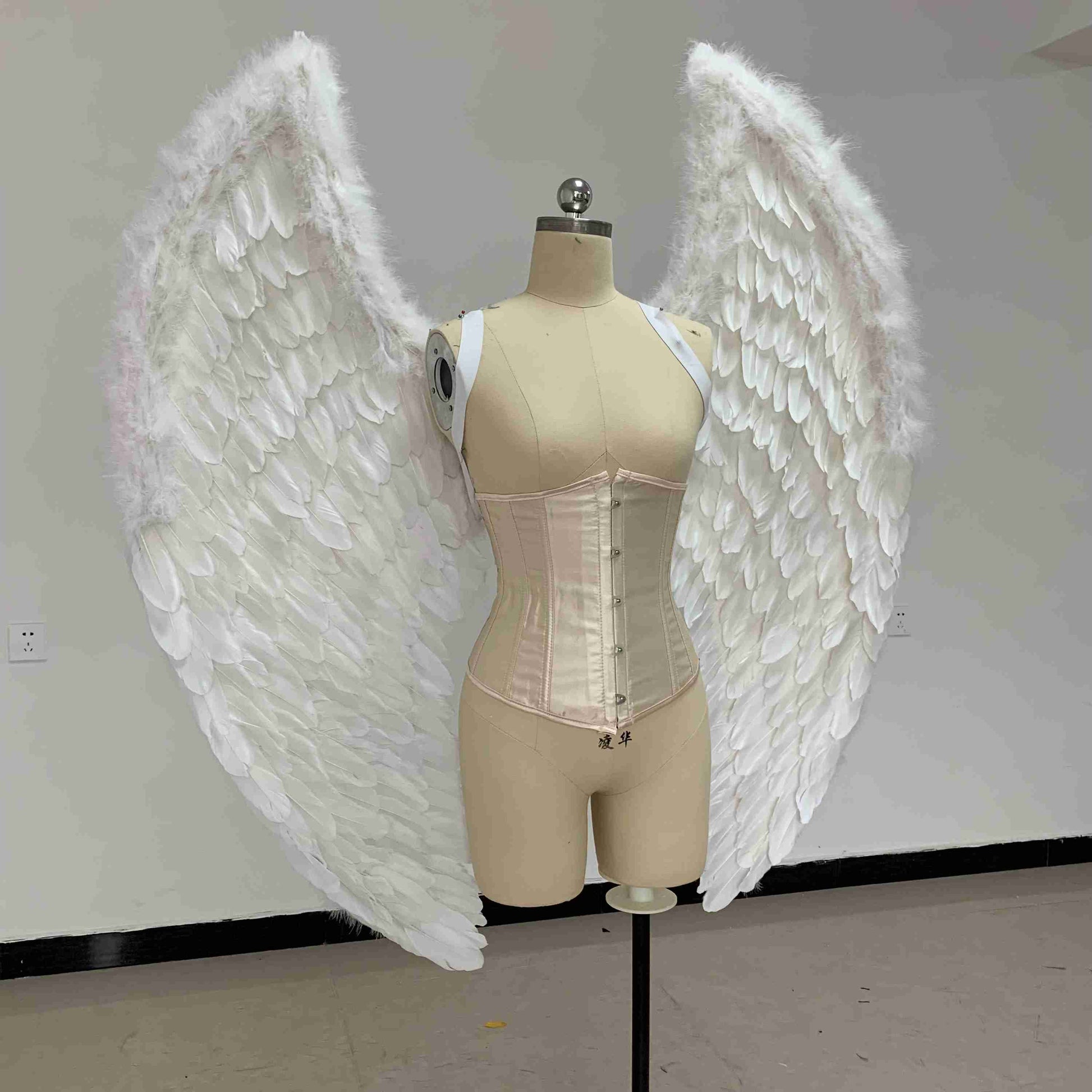 Our small white color angel wings from the side. Made from goose feathers. Wings for angel costume. Suitable for photoshoots.