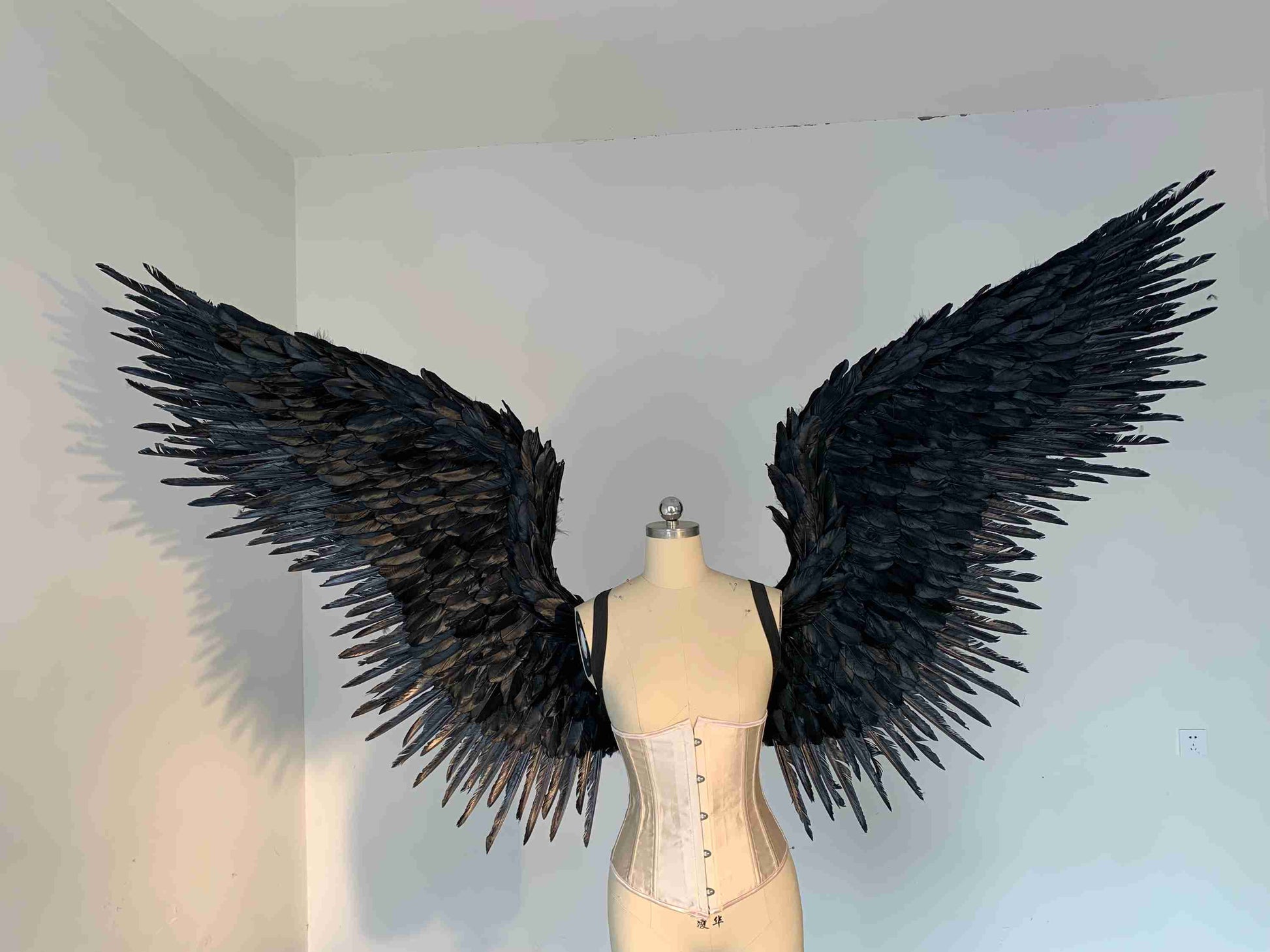 Our black color angel wings from the front. Made from goose feathers. Wings for angel costume or devil costume. Suitable for photoshoots.