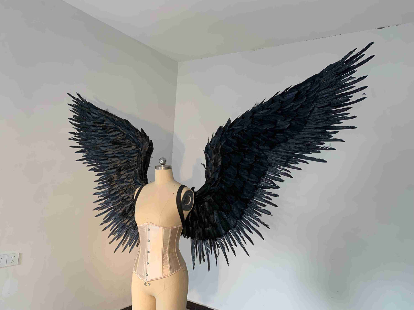Our black color angel wings from the left side. Made from goose feathers. Wings for angel costume or devil costume. Suitable for photoshoots.
