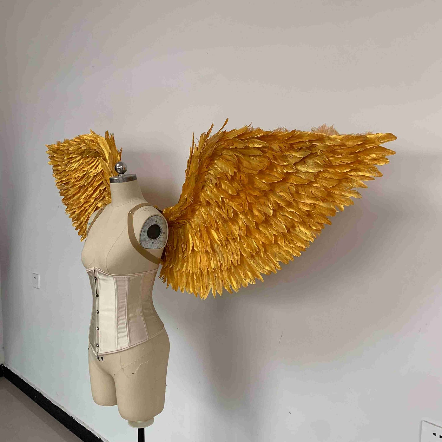 Our golden angel wings from the left side. Made from goose feathers. Wings for angel costume. Suitable for photoshoots.