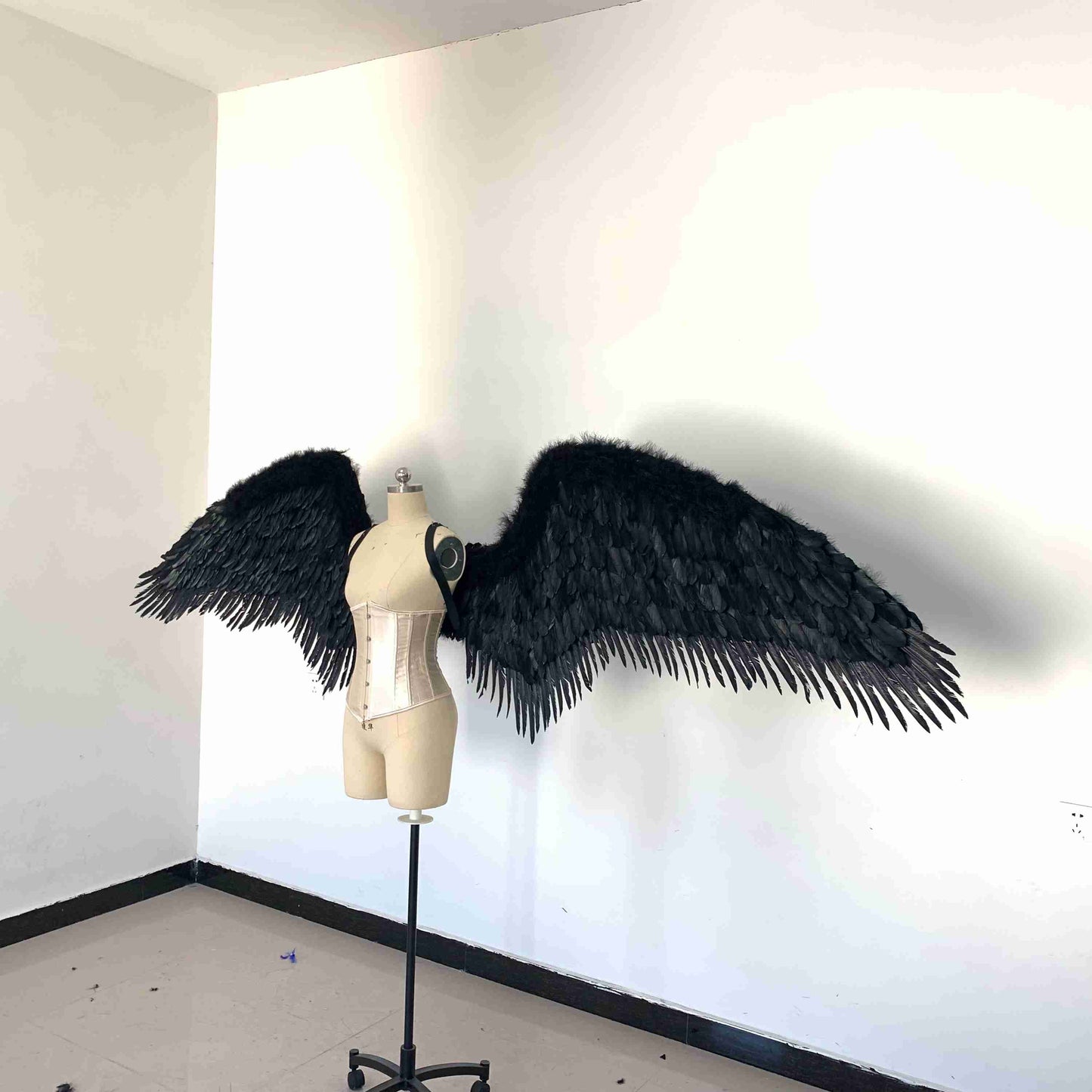Our black fallen angel wings from the left side. Made from goose feathers. Wings for the devil or fallen angel costume. Suitable for photoshoots.