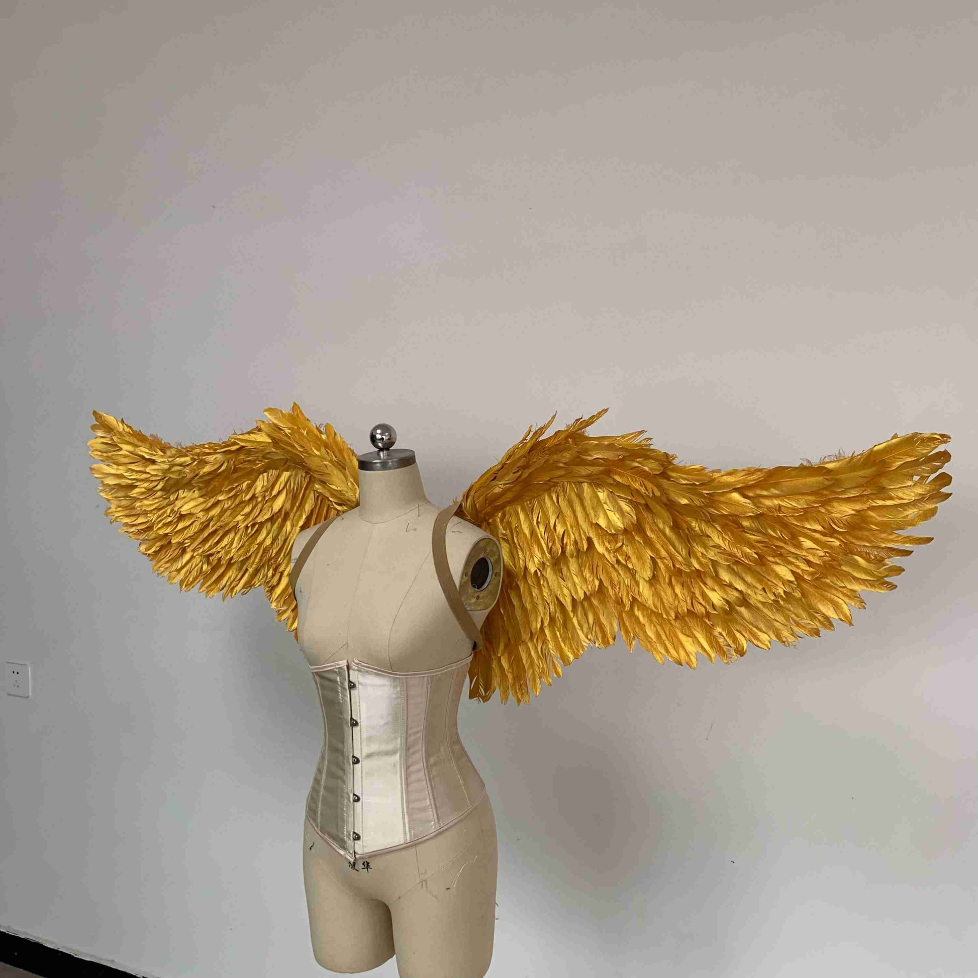 Our small golden angel wings from the left side. Made from goose feathers. Wings for angel costume. Suitable for photoshoots.