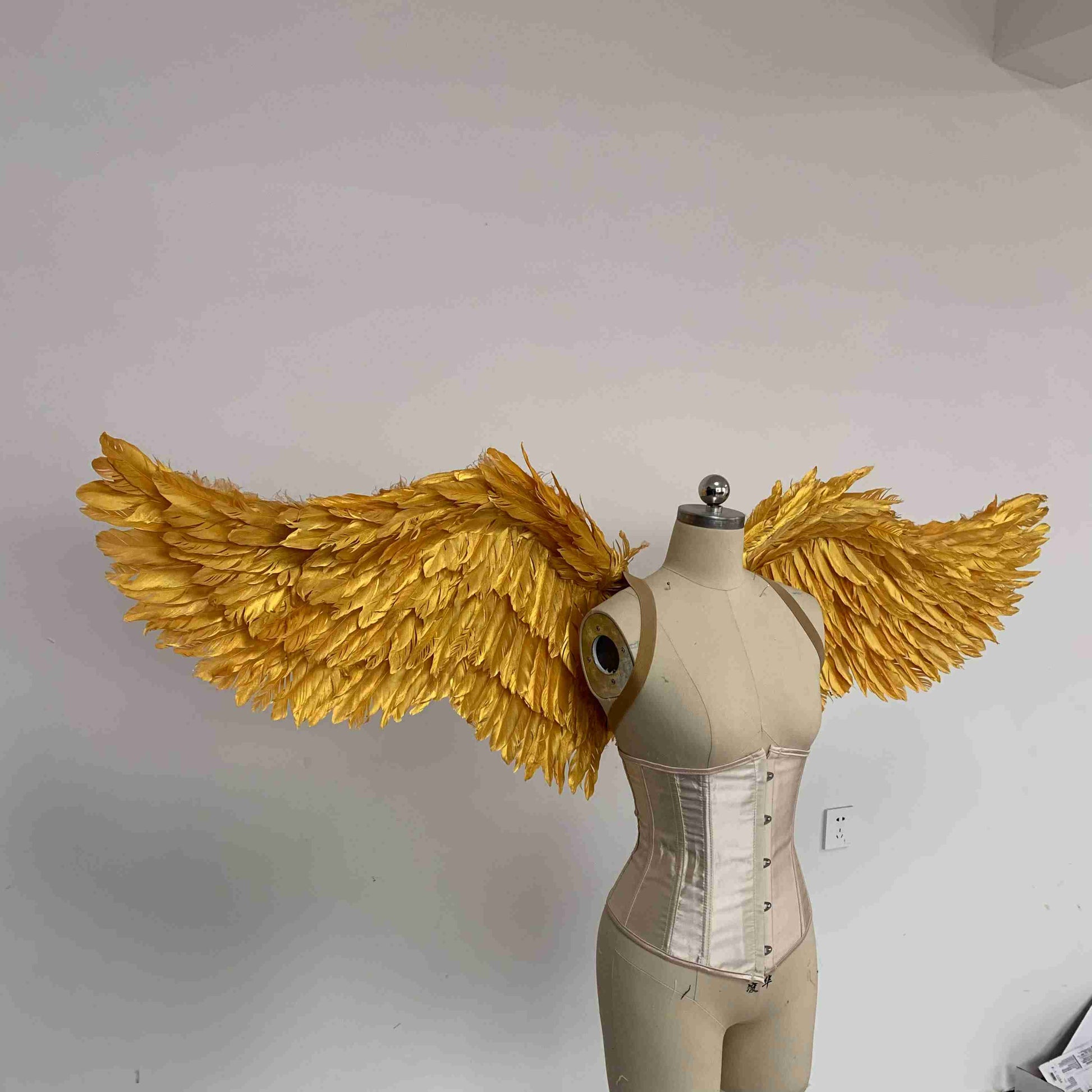 Our small golden angel wings from the right side. Made from goose feathers. Wings for angel costume. Suitable for photoshoots.