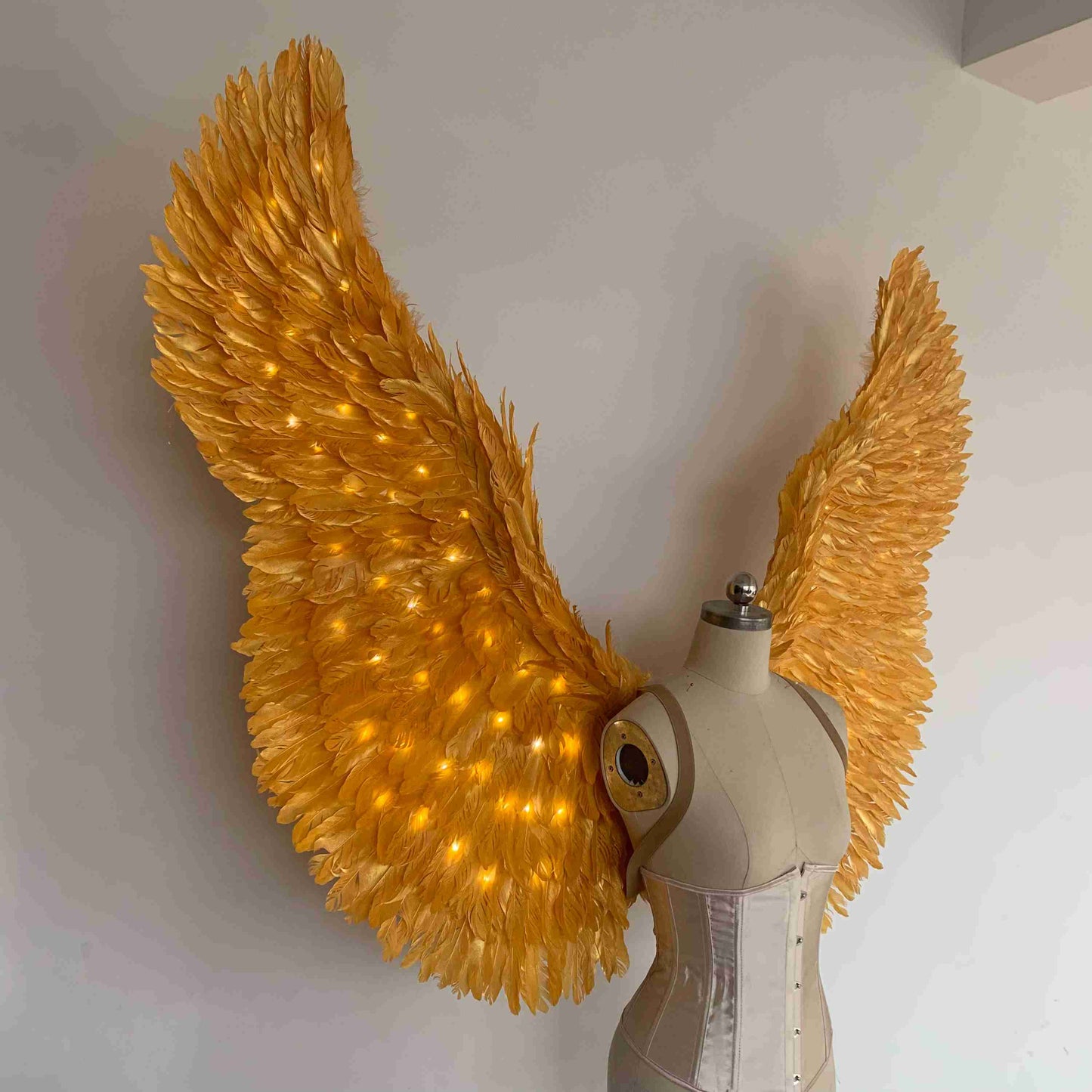 Our gold color angel wings from the right side. Made from goose feathers with LED lights inside. Wings for angel costume. Suitable for photoshoots.