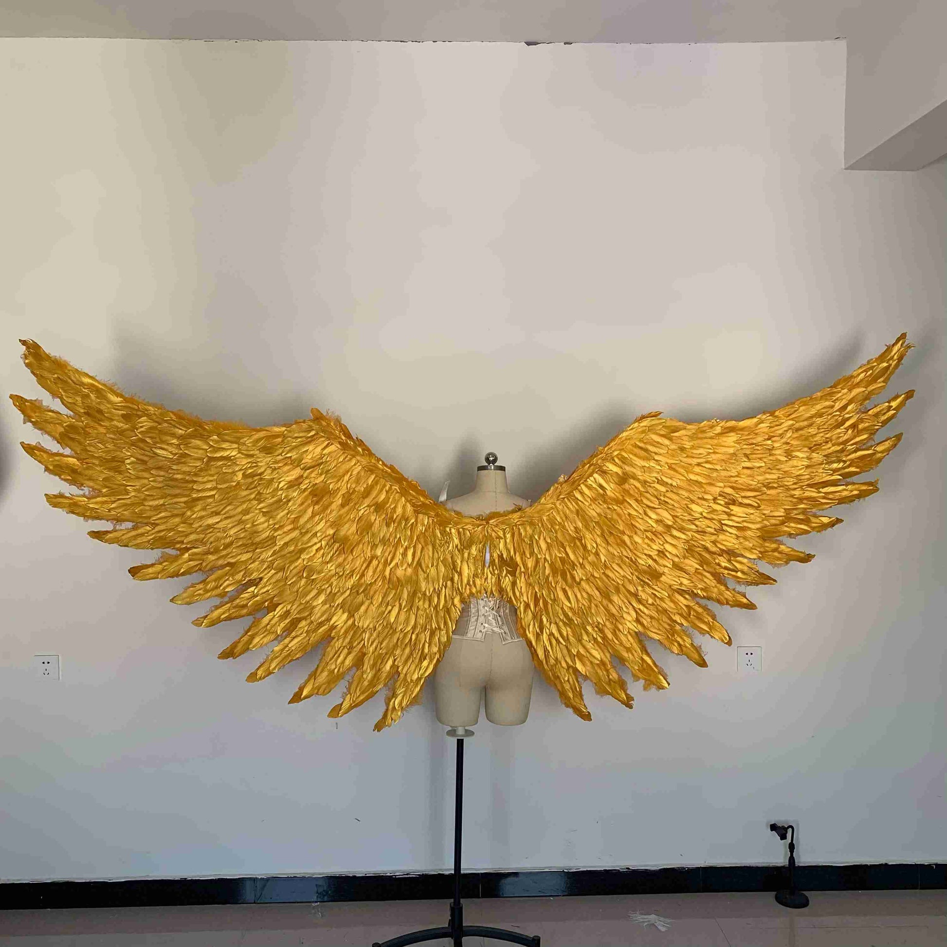 Our big golden angel wings from the back. Made from goose feathers. Wings for angel costume. Suitable for photoshoots.