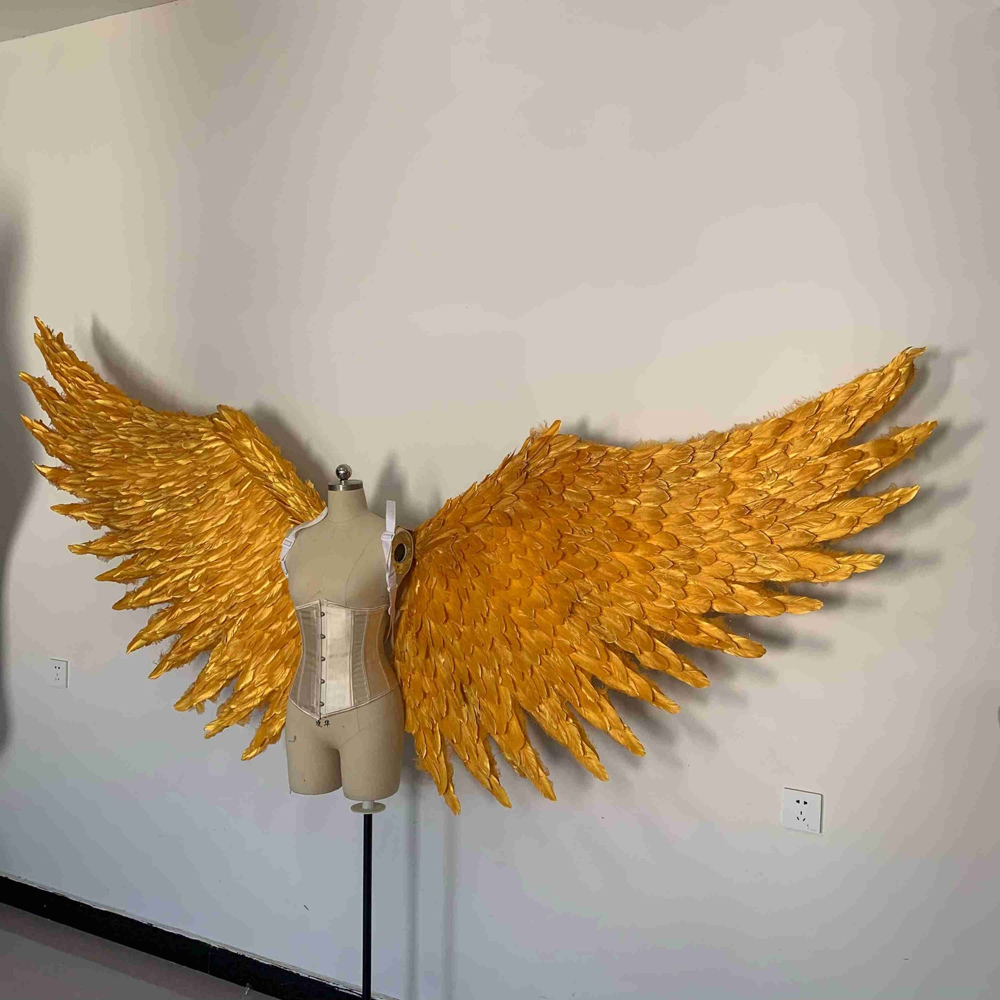 Our big golden angel wings from the left side. Made from goose feathers. Wings for angel costume. Suitable for photoshoots.