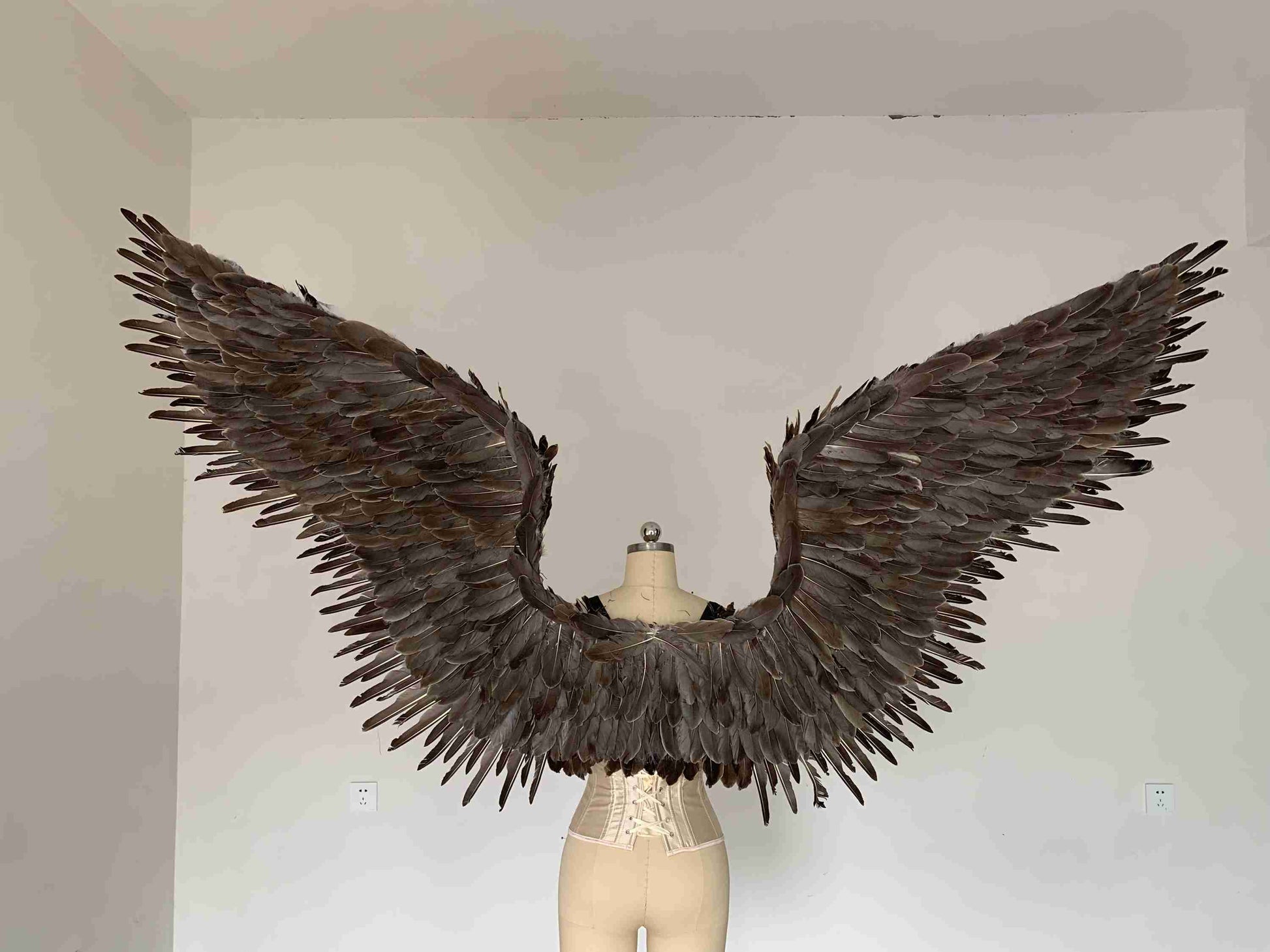 Our grey color angel wings from the back. Made from goose feathers. Wings for angel costume or devil costume. Suitable for photoshoots.