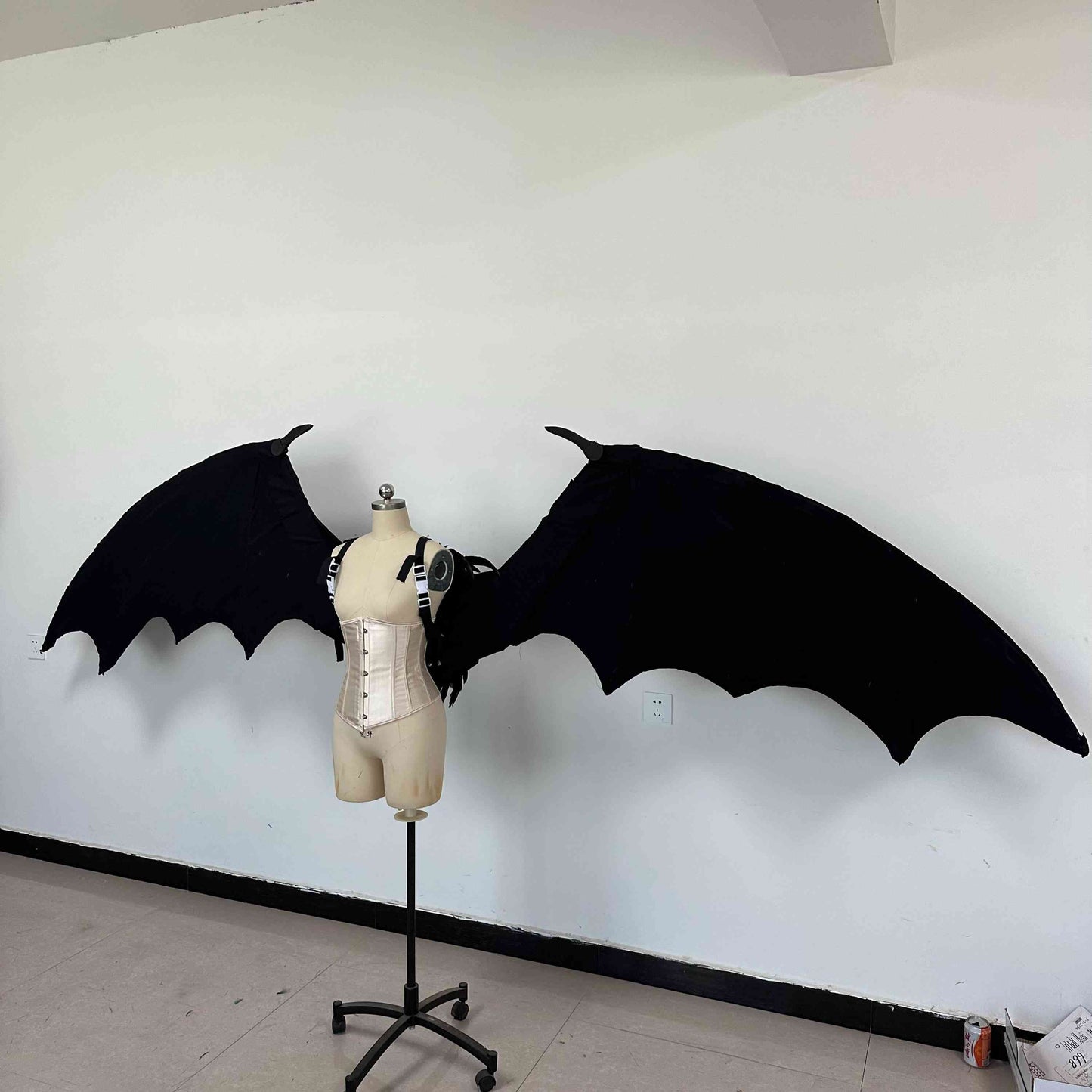 Our large black color devil wings from the left side. Wings are moveable and can control extension and folding remotely. Made from aluminum alloy and cloth. Wings for fallen angel costume or devil costume. Suitable for fantasy photoshoots or events.