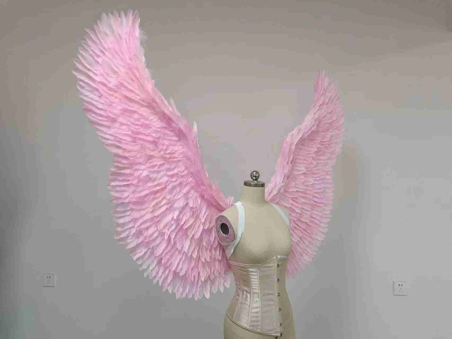 Our pink color angel wings from the right side. Made from goose feathers. Wings for the devil or angel costume. Suitable for photoshoots.