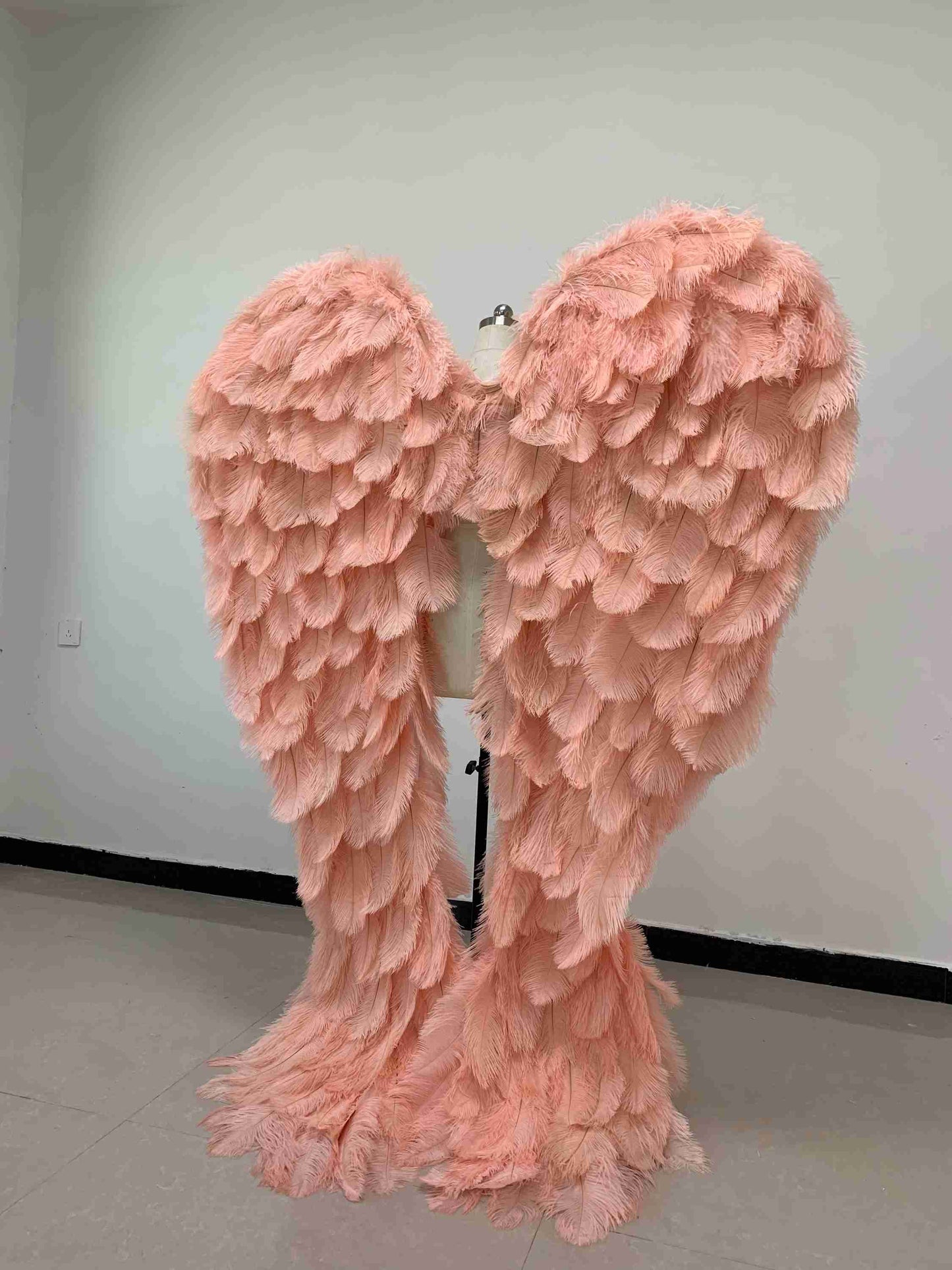 Our luxury pink angel wings from the back. Made from ostrich feathers. Wings for angel costume. Suitable for photoshoots especially for boudoirs.