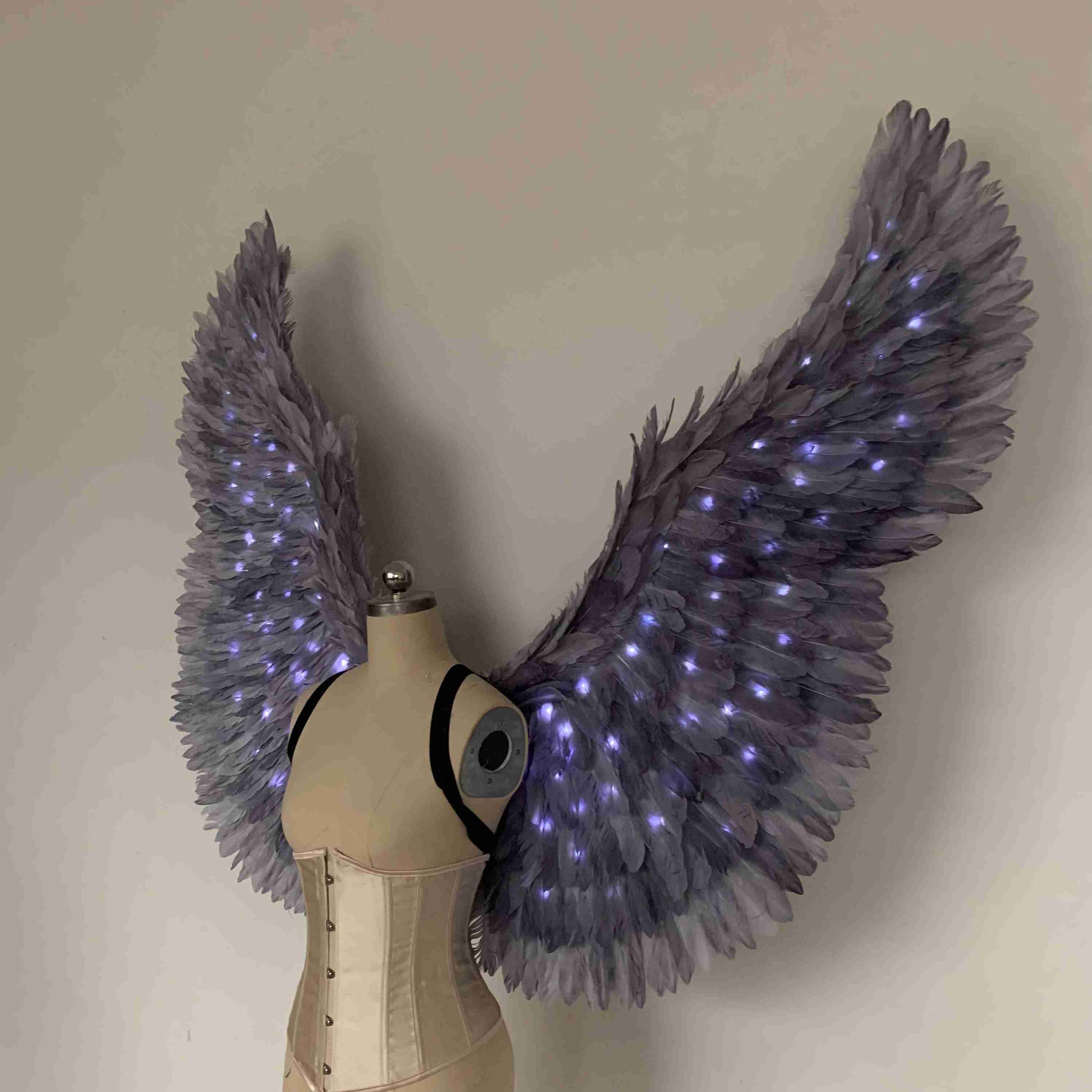 Our purple color angel wings from the left side. Made from goose feathers with LED lights inside. Wings for angel costume. Suitable for photoshoots.