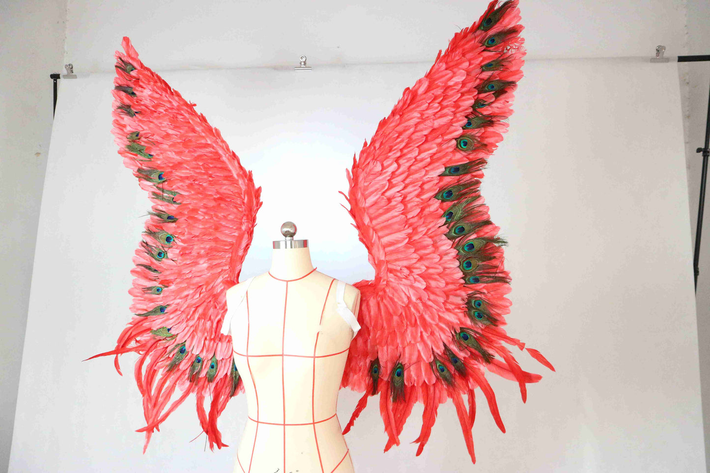 Our red peacock angel wings from the left side. Made from goose feathers and peacock feathers. Wings for angel wings costume. Suitable for photoshoots.