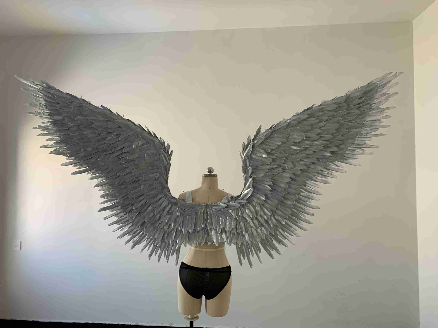 Our silver color angel wings from the back. Made from goose feathers. Wings for angel costume or devil costume. Suitable for photoshoots.