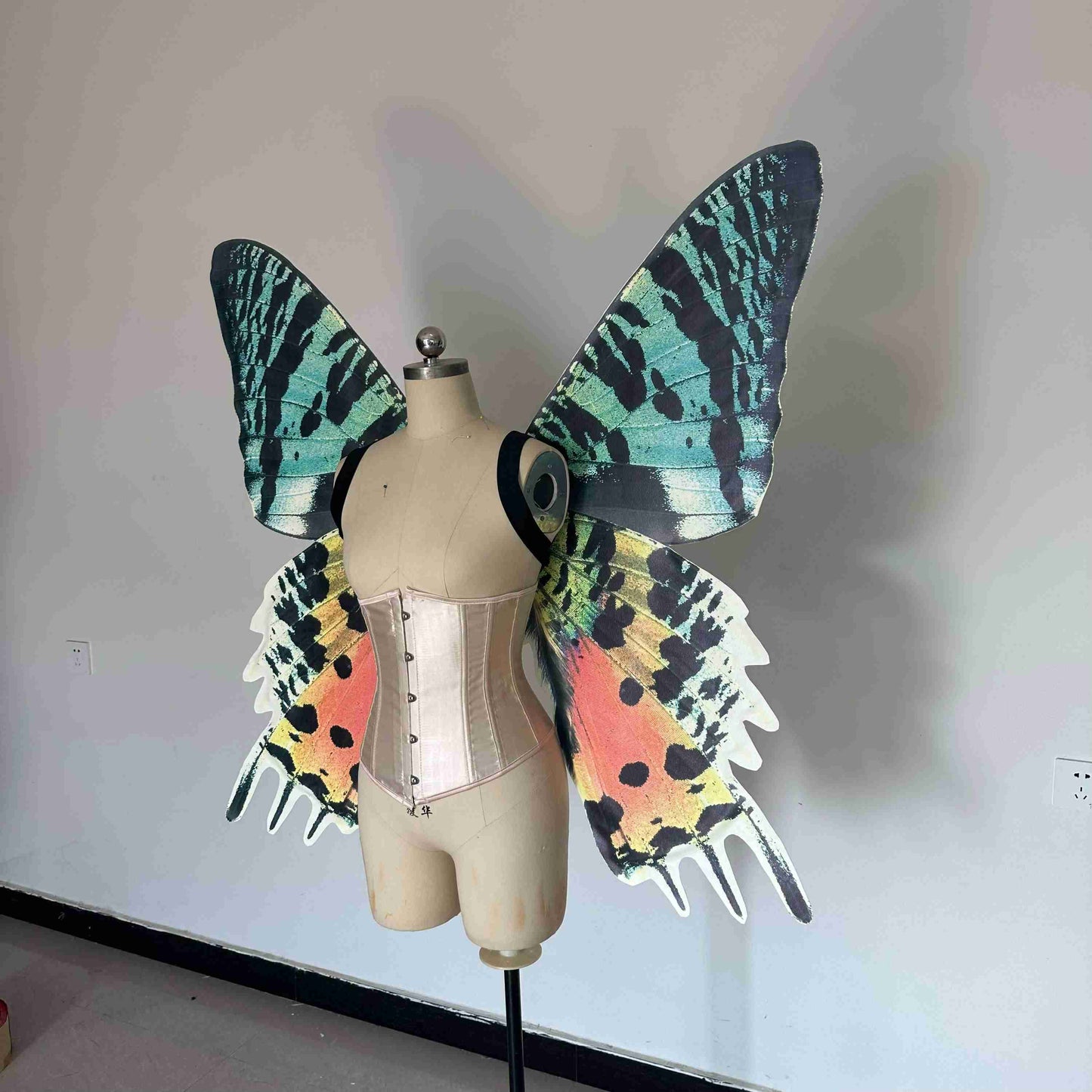 Our sky orange butterfly wings from the left side. Made from cloth. Can be also named fairy wings or pixie wings.