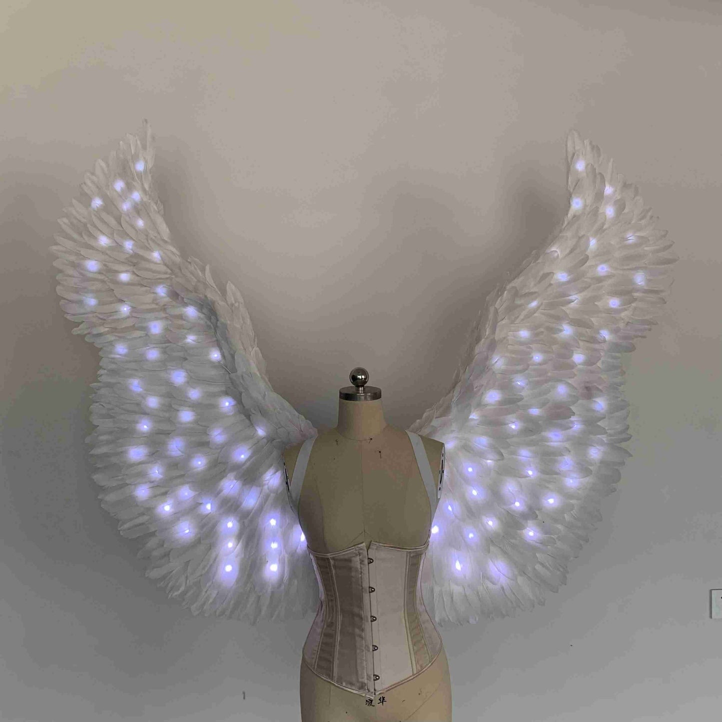 Our white color angel wings from the front. Made from goose feathers with LED lights inside. Wings for angel costume. Suitable for photoshoots.