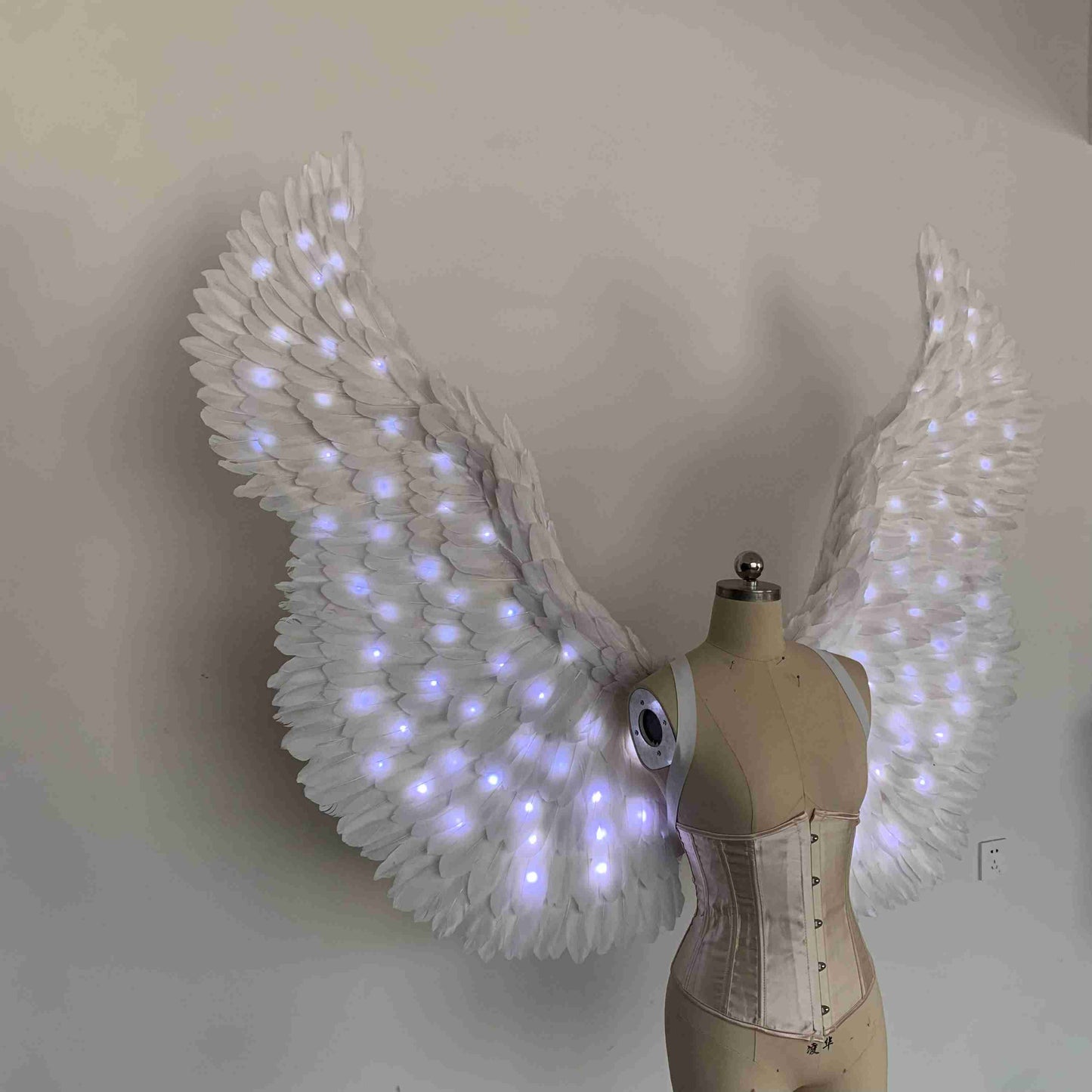 Our white color angel wings from the right side. Made from goose feathers with LED lights inside. Wings for angel costume. Suitable for photoshoots.